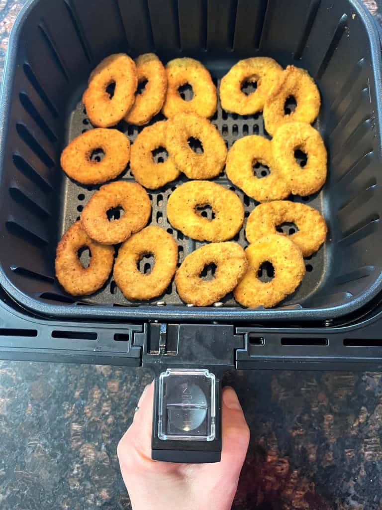 Golden, crispy White Castle chicken rings arranged in an air fryer basket, fresh out of the air fryer, ready to serve.