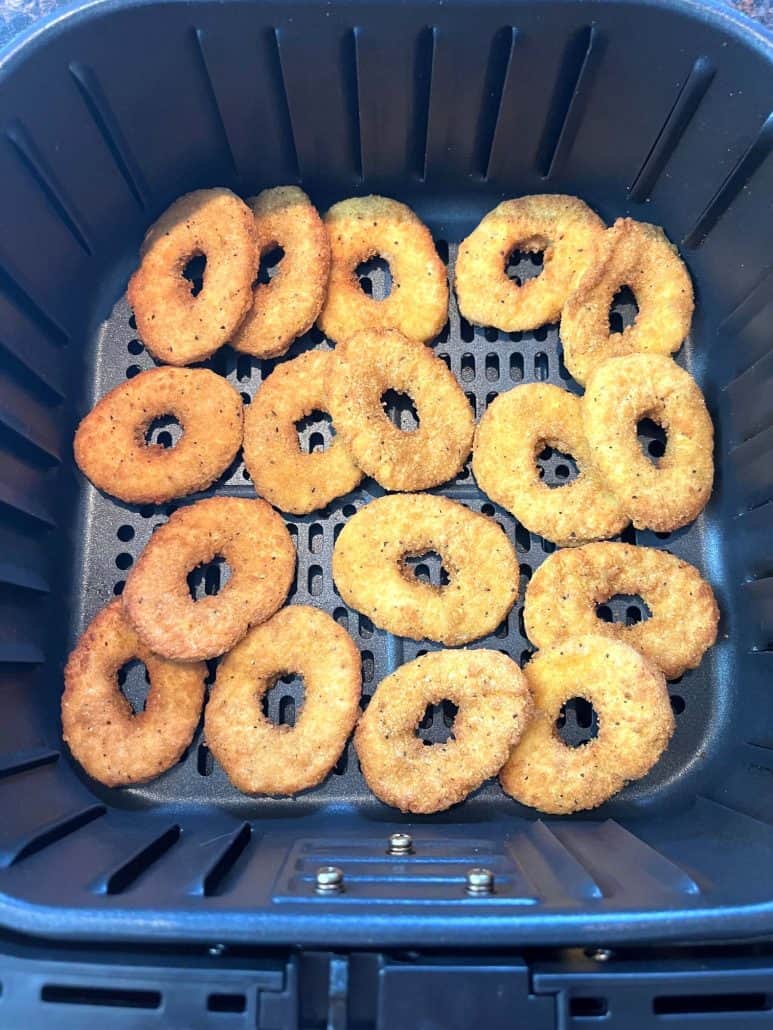 Top view of perfectly cooked White Castle chicken rings arranged in an air fryer basket, showcasing their crispy golden texture.