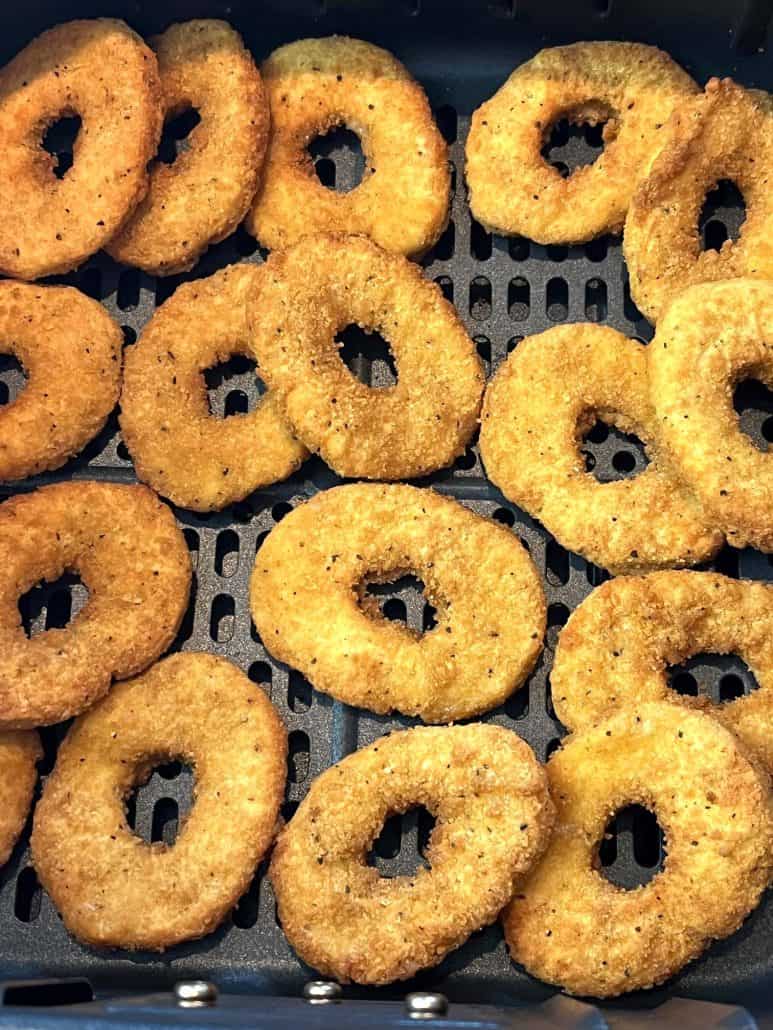 Close-up of golden, crispy White Castle chicken rings arranged in an air fryer basket.