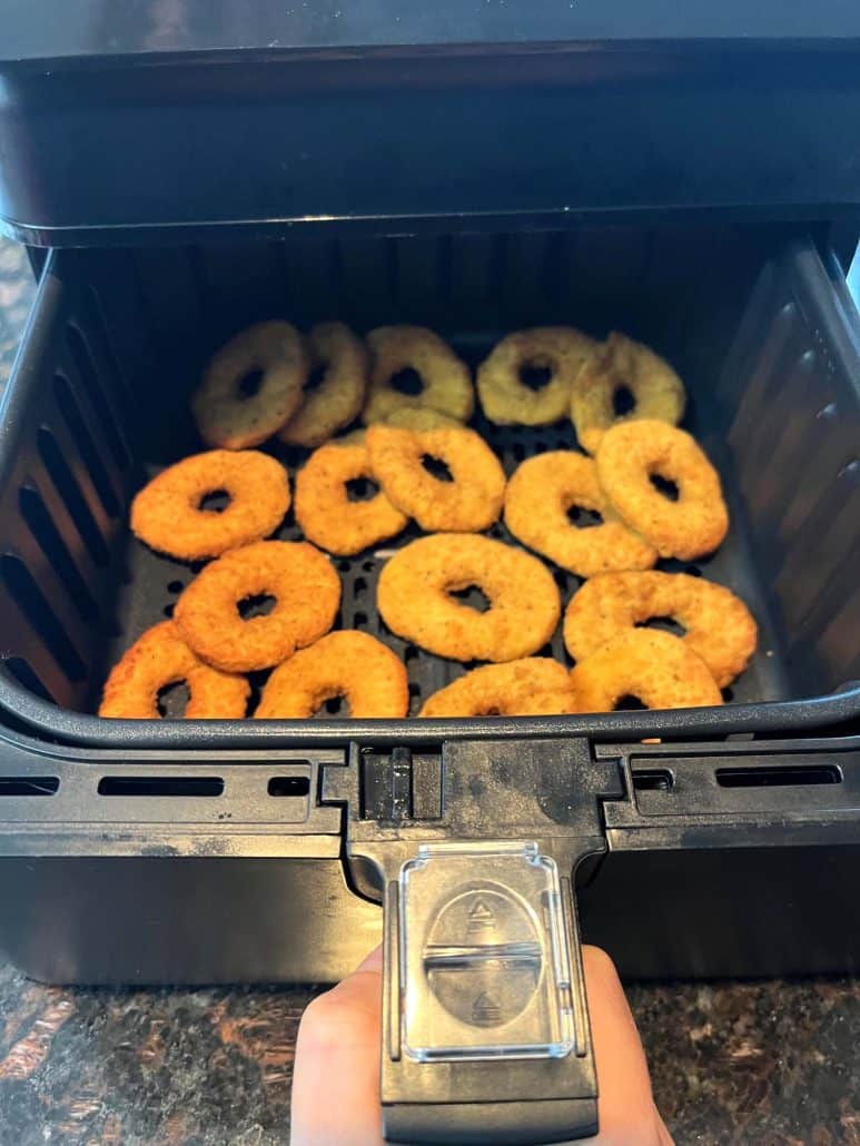 Freshly cooked White Castle chicken rings in an air fryer basket.