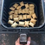 Air fryer basket filled with crispy Totinos Snack Bites arranged in a single layer, ready to be cooked.