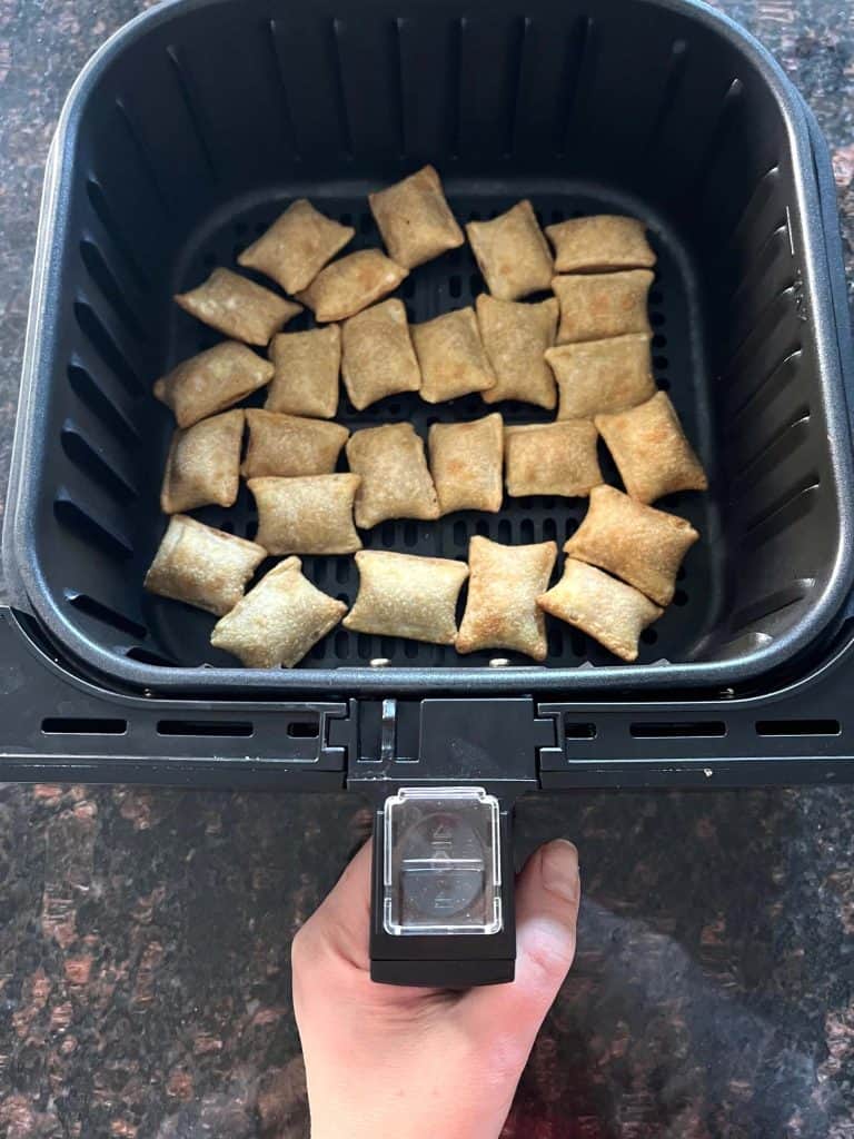 Air fryer basket filled with crispy Totinos Snack Bites arranged in a single layer, ready to be cooked.