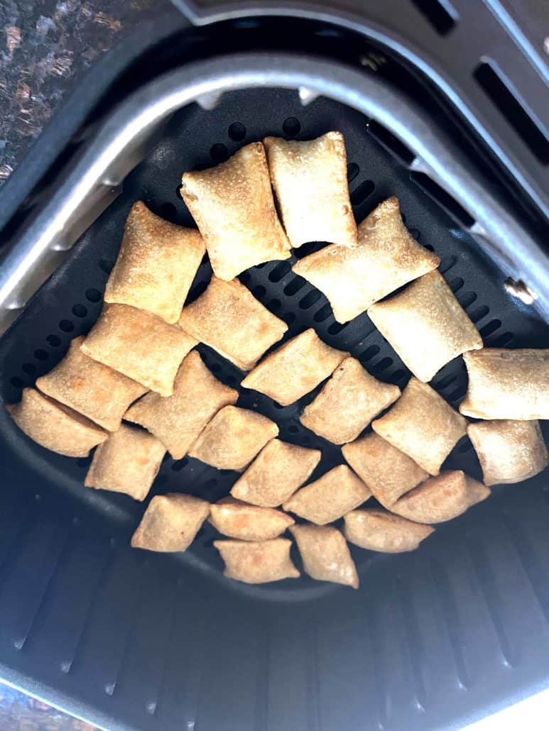  Totino's Breakfast Snack Bites arranged in a single layer inside an air fryer basket, highlighting their golden, crispy texture during cooking.