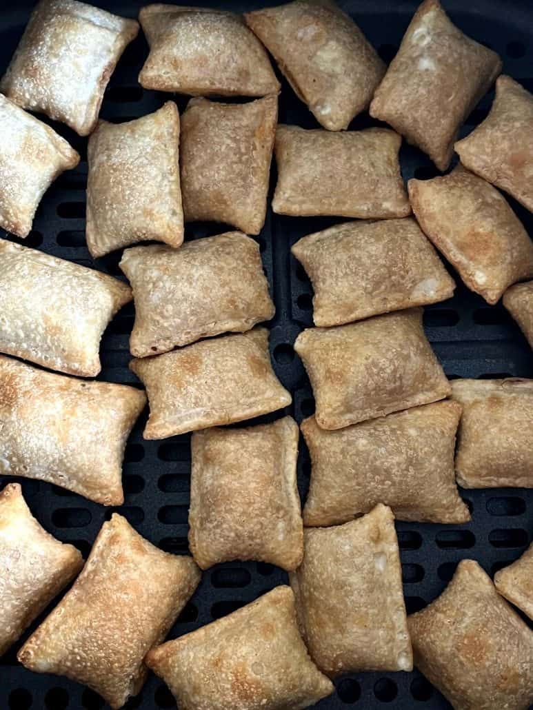 Close-up of golden brown Totino's Breakfast Snack Bites in an air fryer basket, showing their crispy texture after air frying.