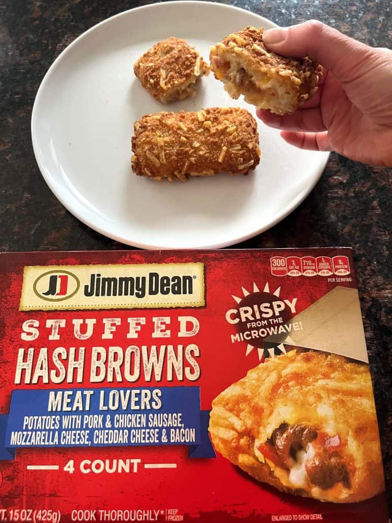 Jimmy Dean Stuffed Hash Browns package in the foreground with a plate of crispy hashbrowns in the background, one split open to reveal the cheesy filling.