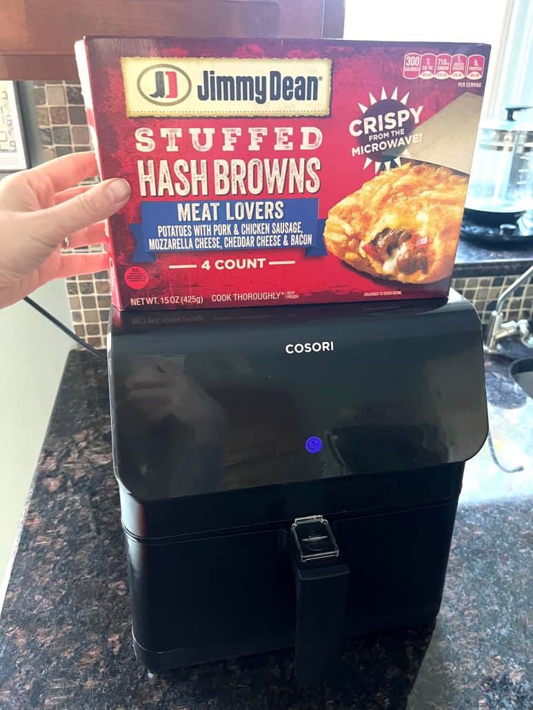 Jimmy Dean Stuffed Hash Browns package held above an air fryer, showcasing the key ingredients used in the recipe for crispy and cheesy hashbrowns.