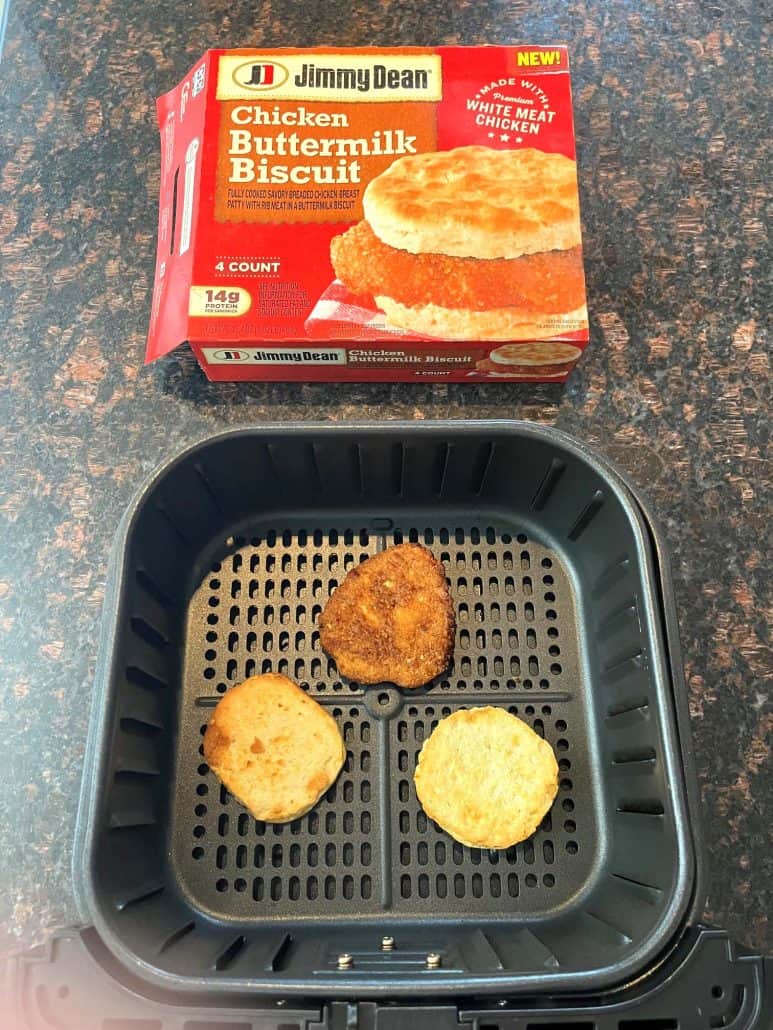 Jimmy Dean Chicken Buttermilk Biscuit sandwich in the air fryer basket, alongside the product box, ready to serve.