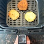 Air fryer basket with three crispy breaded chicken patties, showing the cooking process for a Jimmy Dean Chicken Buttermilk Biscuit Sandwich recipe.