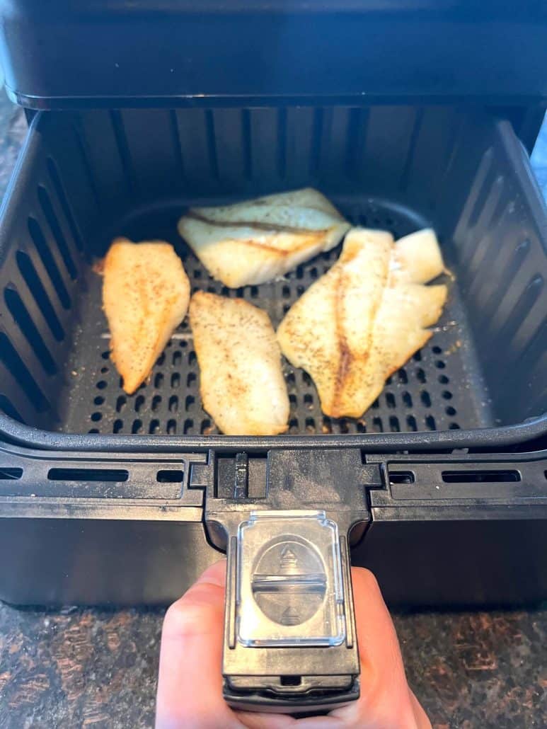 Freshly air-fried orange roughy fillets in the air fryer basket.