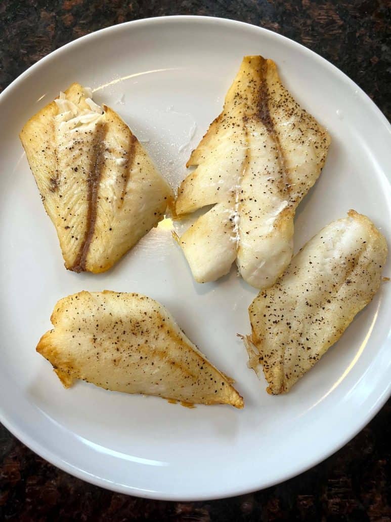 Air-fried orange roughy fillets served on a white plate, perfectly cooked with a flaky texture and light seasoning.