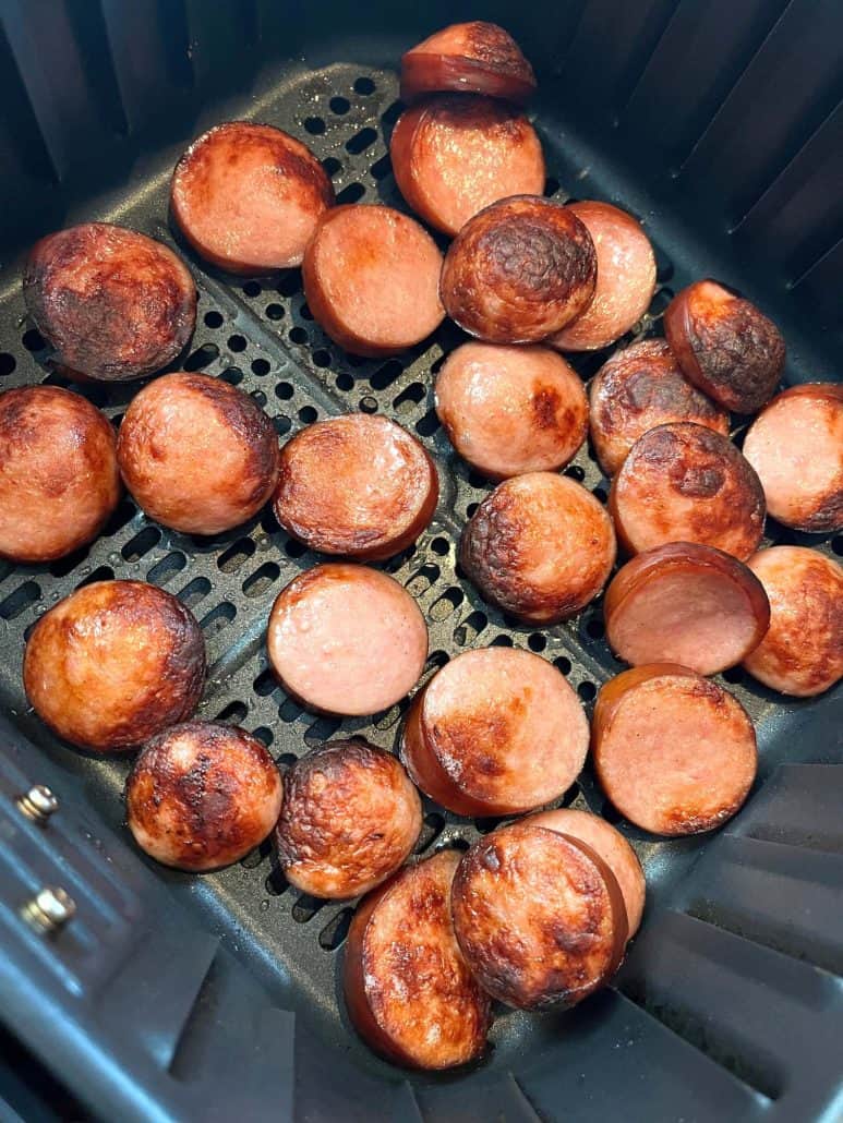 Air fryer basket filled with crispy, golden-brown ring bologna slices, perfectly cooked and ready to enjoy.