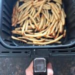 Crispy beer battered fries cooked in an air fryer basket, ready to serve.